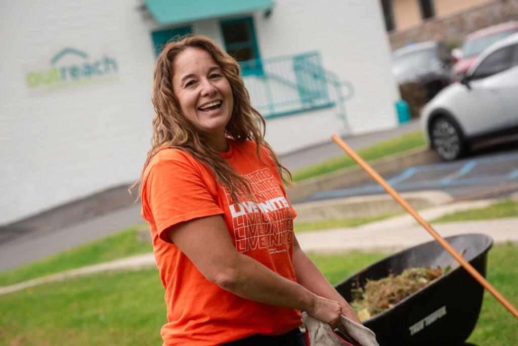 Day of Caring volunteer smiling while planting.